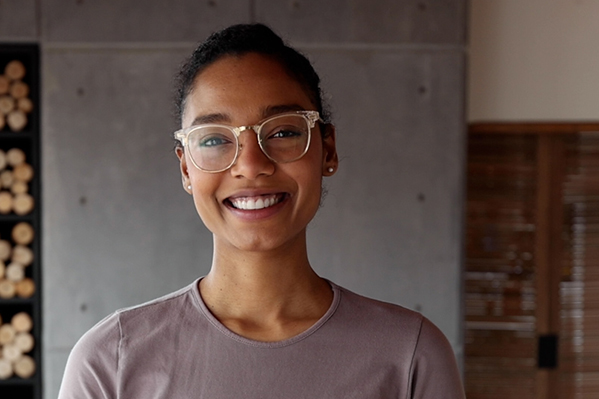 young confident woman wearing glasses smiling directly into the camera