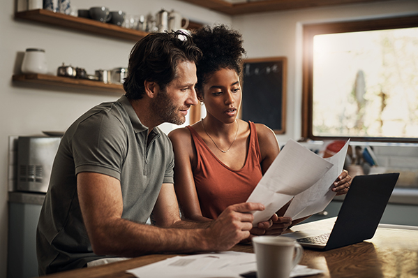 dad helping his young adult daughter review paper printouts