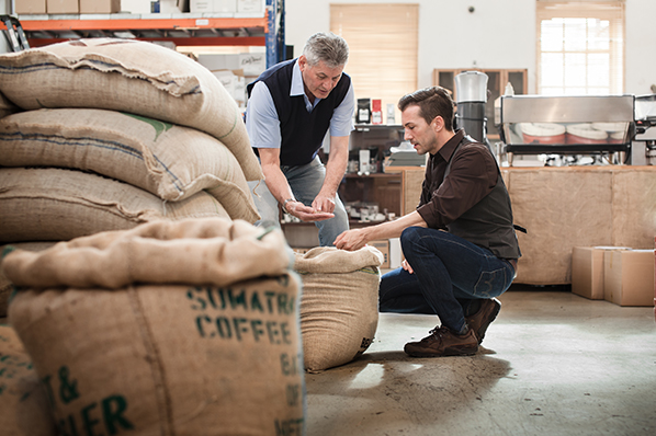 two male business partners inspecting their coffee bean stock
