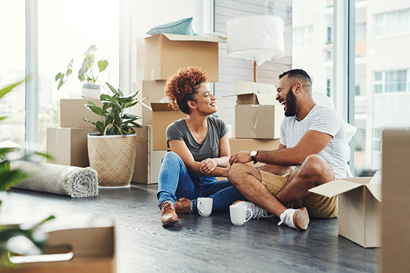 couple sitting together smiling with moving boxes