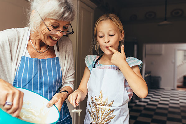 child-baking-with-grandma-and-tasting-batter