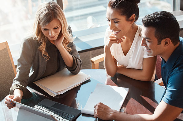 advisor sitting down with married couple going over their finances