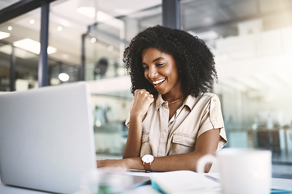 young woman smiling looking at her laptop