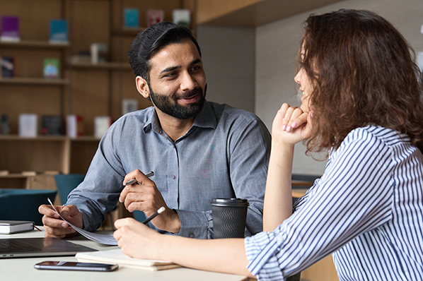 couple sitting at the kitchen table chatting looking at documents