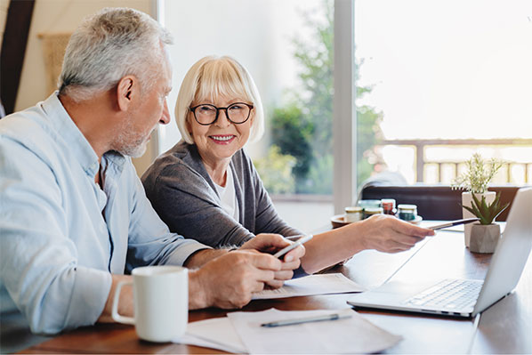 older couple doing finances at home on the laptop