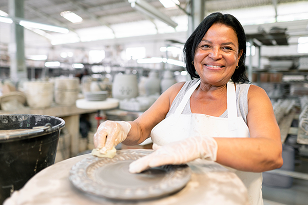 middle-aged woman working at a bakery smiling at the camera