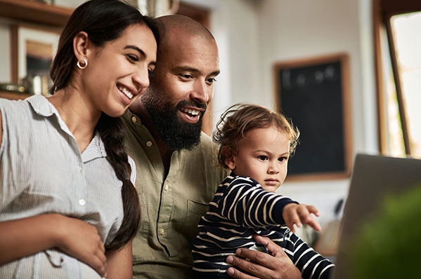 mom and dad with a young son looking at their laptop