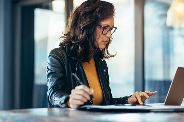 woman sitting at desk working on her laptop