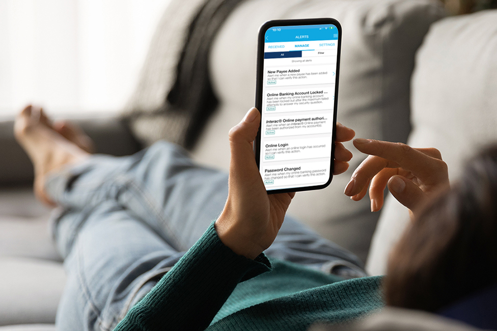 woman lying on couch, setting up mobile banking alerts