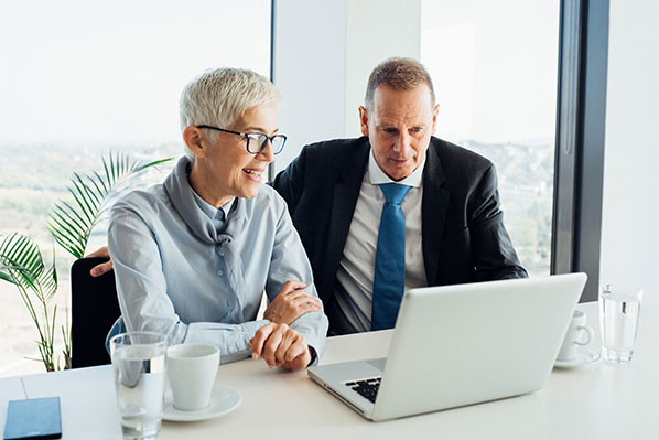 mature couple sitting down having a conversation at a laptop